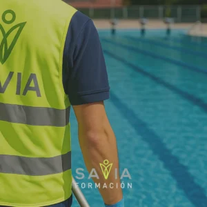 Técnico de mantenimiento de piscinas con chaleco reflectante con el logotipo del centro de formación Savia Formación junto a una piscina. Imagen del curso online de mantenimiento de piscinas e instalaciones acuáticas (SEA757_2).